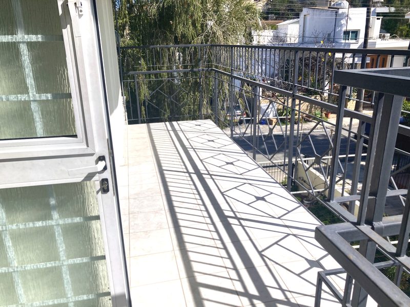 Corner of the balcony surrounded by mature trees and greenery