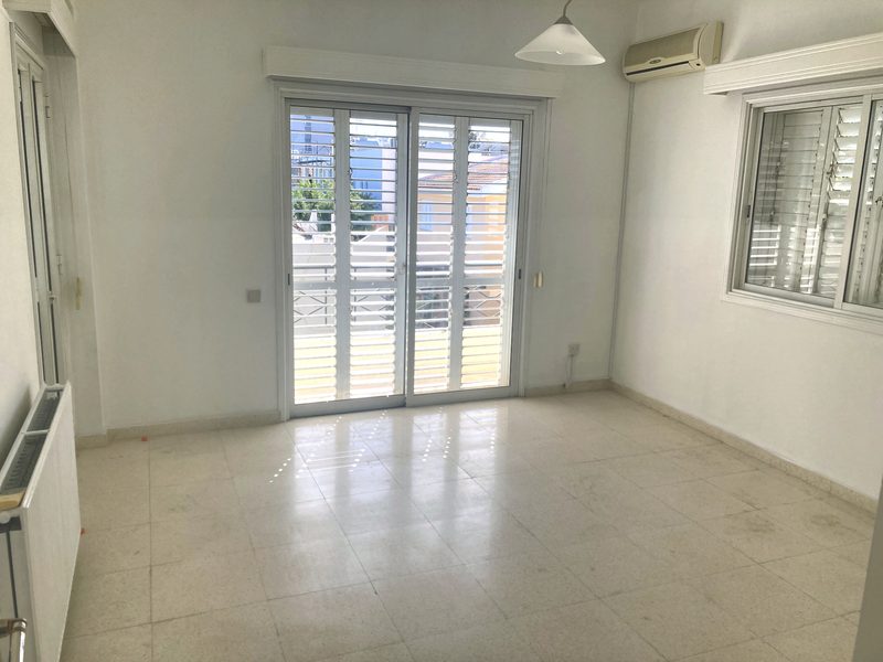 Double bedroom decorated in neutral tones with wall-mounted air conditioning and a balcony door