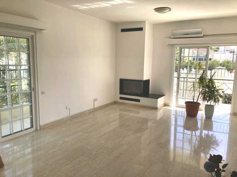 Spacious living room with a modern black corner fireplace, marble-effect floor and doors to the balcony